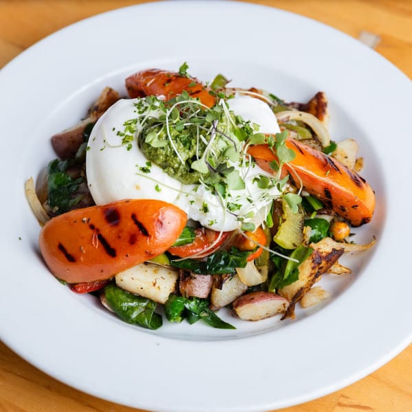 Fandee's Restaurant's breakfast skillet with poached eggs, grilled peppers, potatoes, and greens.