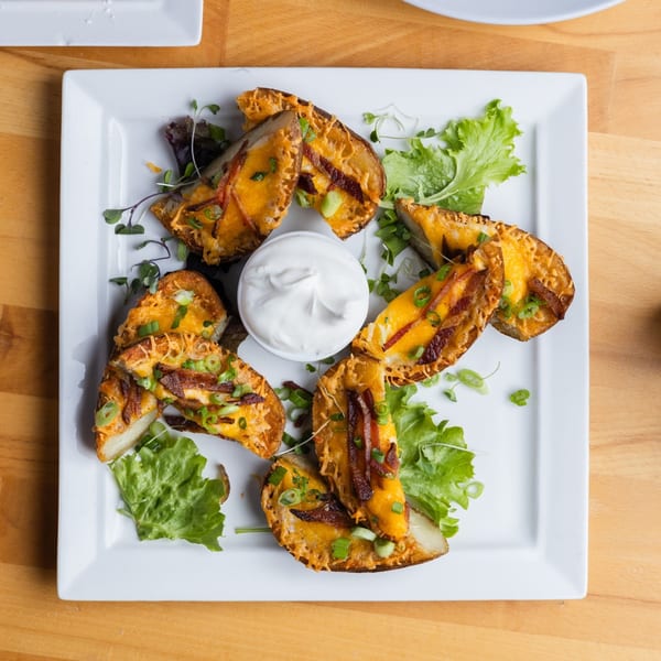 Fandee's Restaurant Sebastopol's potato skins, topped with cheese, bacon, and green onions, served with sour cream.